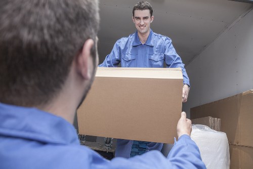 Removal team handling boxes and furniture for an Ealing move